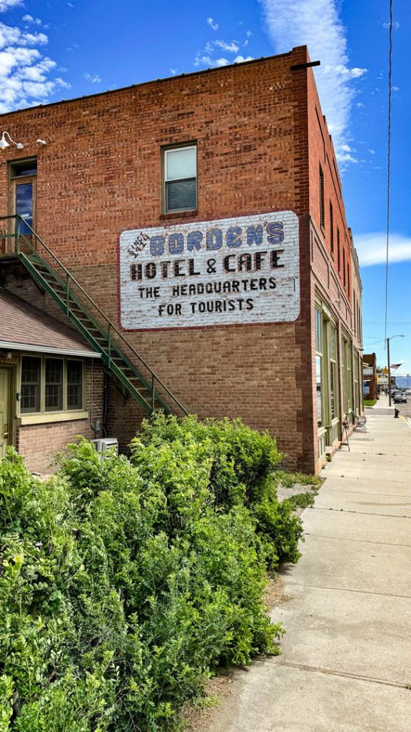 Old hotel and cafe sign painted on a brick wall.